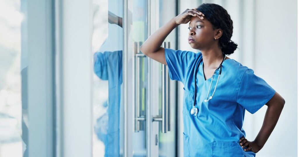 Nurse looking tired with hand on her head