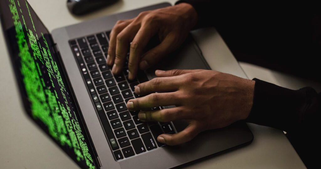 Hands typing on laptop