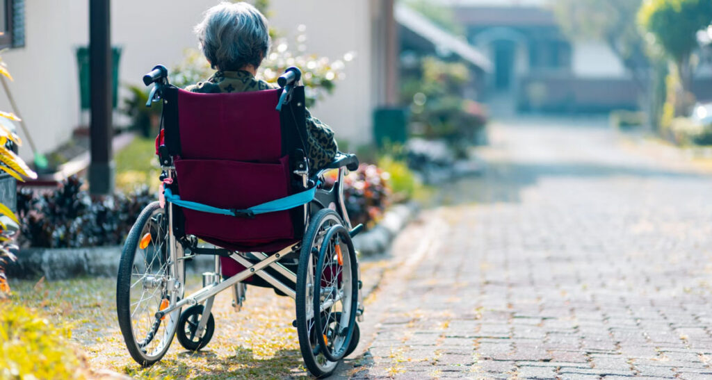 Old lady in a wheelchair staring out into the distance